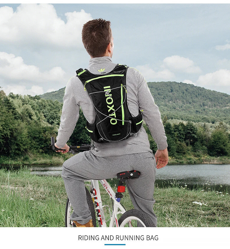 Man wearing OUTDOOR INOXTO hydration vest backpack while cycling in a scenic outdoor setting.