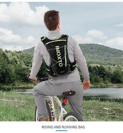 Man wearing OUTDOOR INOXTO hydration vest backpack while cycling in a scenic outdoor setting.
