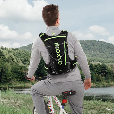 Man wearing OUTDOOR INOXTO hydration vest backpack while cycling near a lake, ideal for running and hiking.
