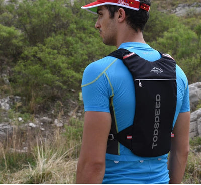 Man wearing an ultralight hydration running vest while hiking in nature, showcasing its breathable design.