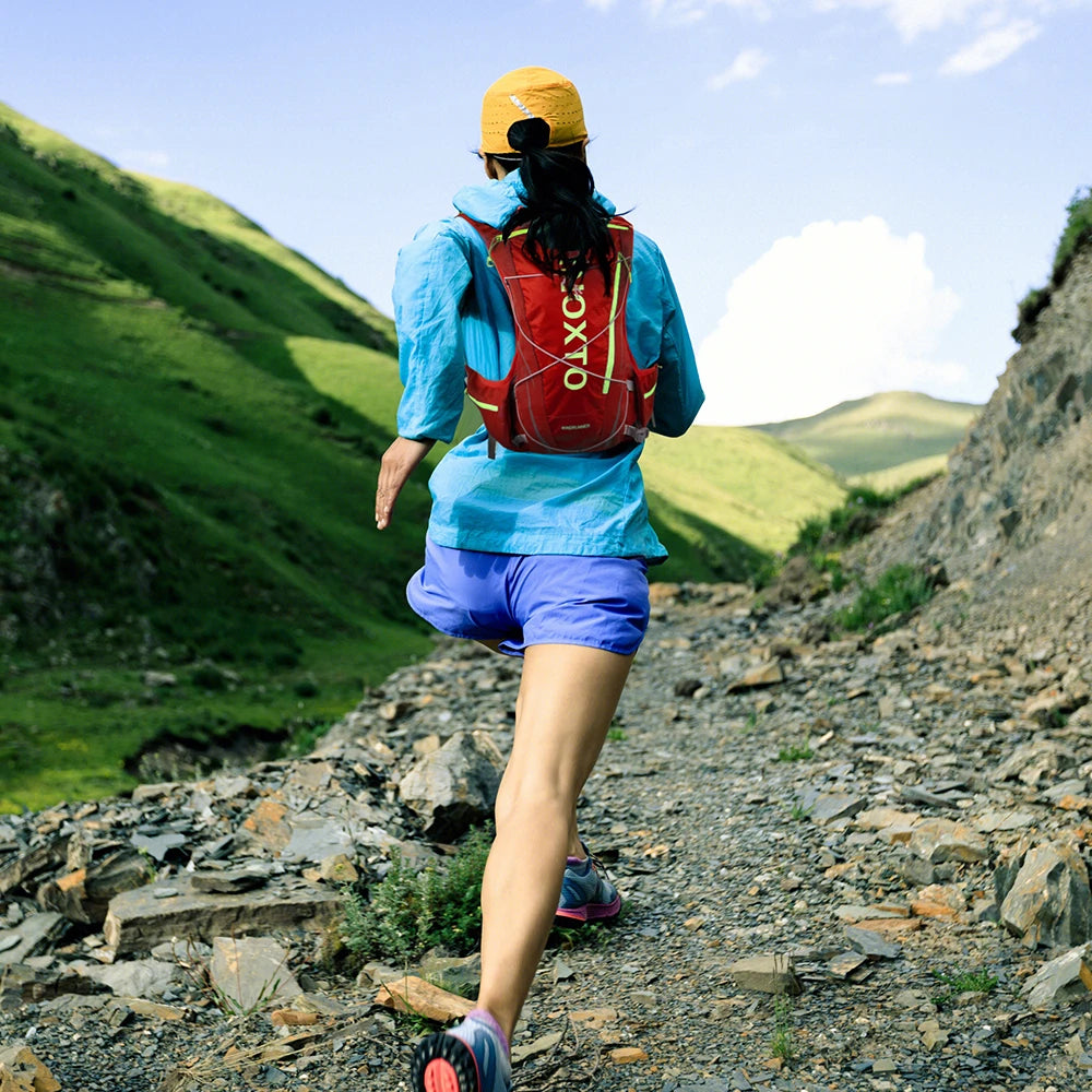Runner in a hydration vest backpack on a rocky trail, ideal for outdoor activities like running, cycling, and hiking.