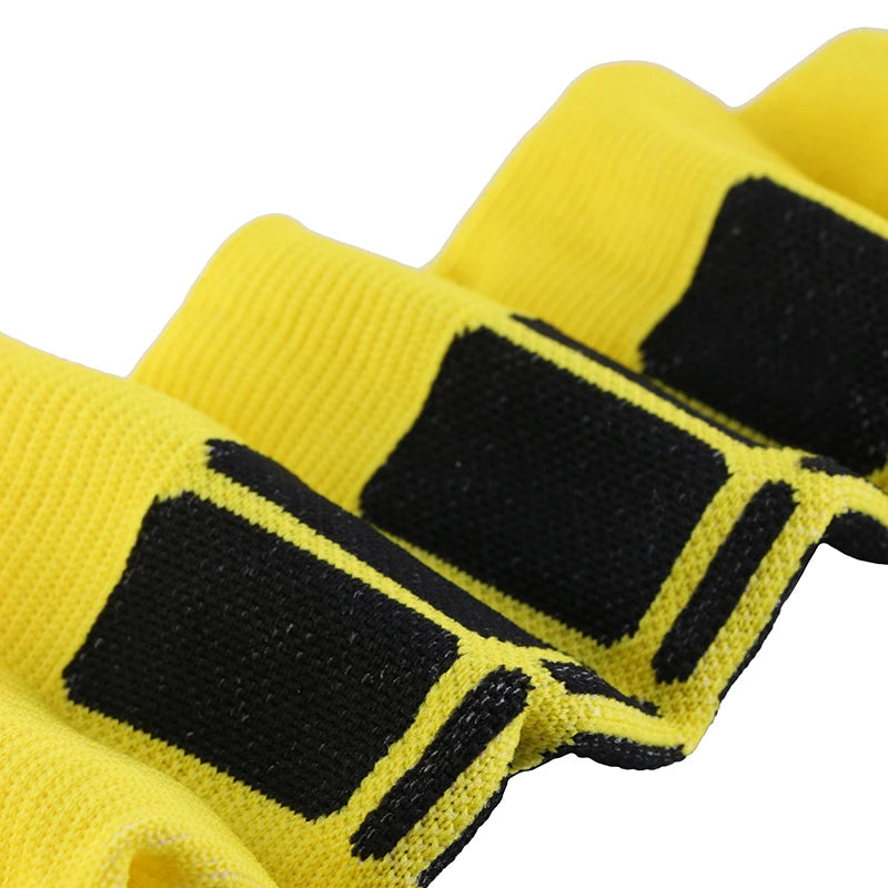 Close-up of yellow compression socks with black geometric patterns, designed for varicose veins relief and sports.