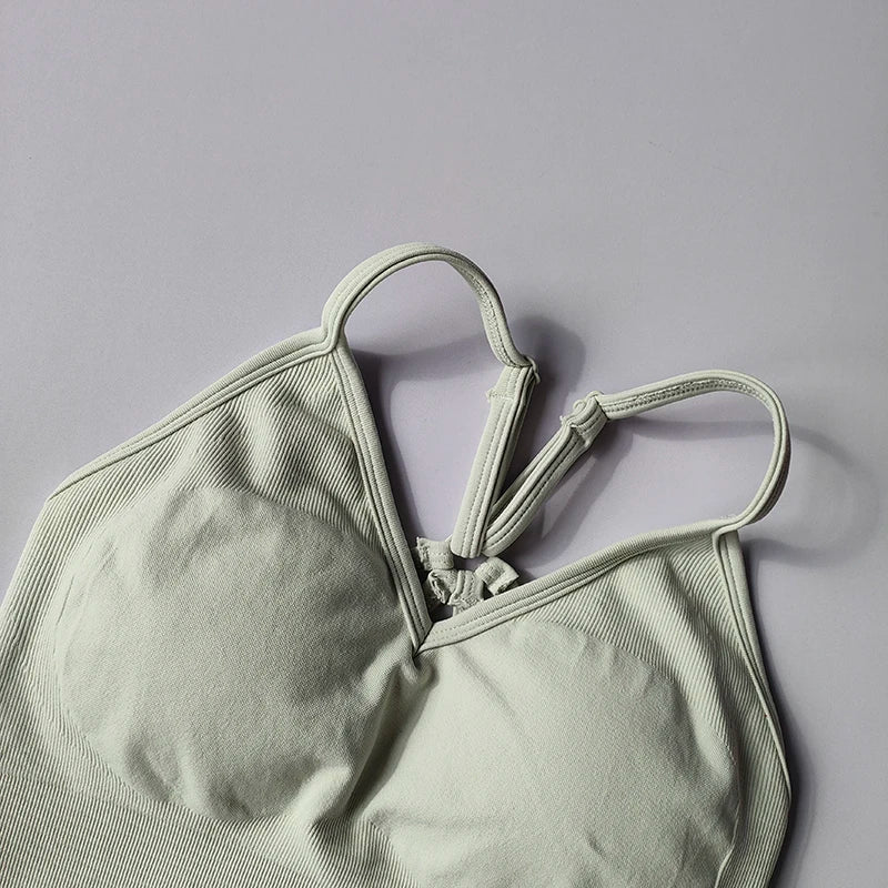 Seamless women's V-neck yoga bra in soft green with racerback design and textured fabric for comfort and support.