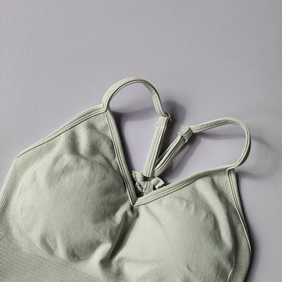 Seamless women's V-neck yoga bra in soft green with racerback design and textured fabric for comfort and support.