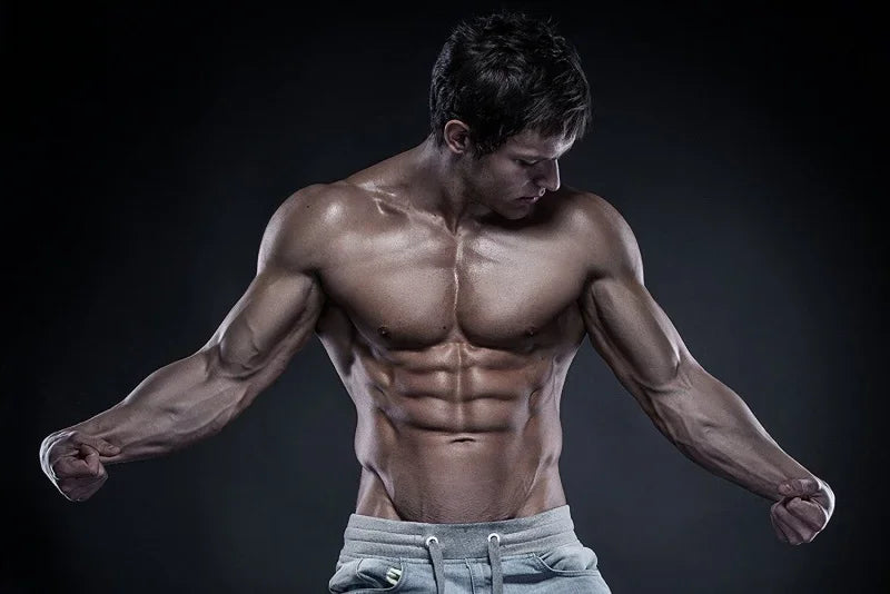 Muscular man showcasing defined abs and arms, representing strength and fitness ideal for anabolic weight gain.