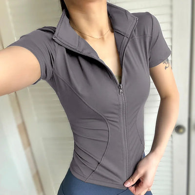 Women’s slim-fitting quick-dry zip shirt in grey with stand collar and short sleeves, ideal for yoga or workouts.