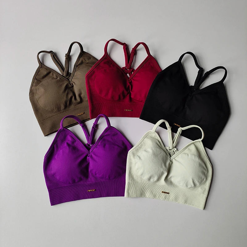 Colorful seamless women's yoga bras in various shades including brown, burgundy, black, purple, and white.