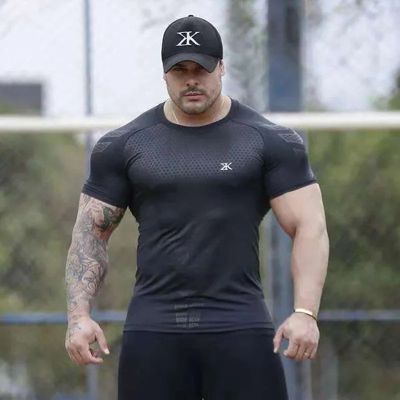 Man in tight-fitting black running shirt and cap, showcasing muscles and athletic build, ideal for fitness and bodybuilding.