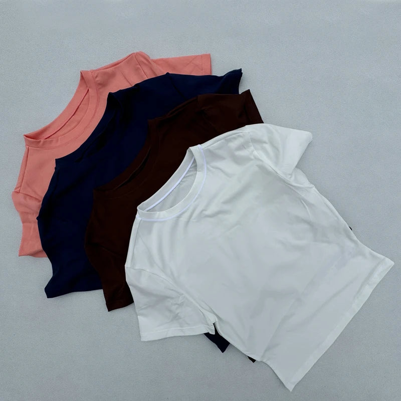 Collection of women's tight fitting sports t-shirts in various colors, ideal for yoga and fitness.