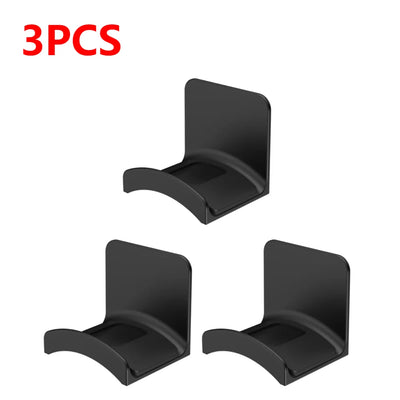 Set of 3 black adhesive headphone hangers for easy mounting on walls or desks, perfect for organizing headphones.