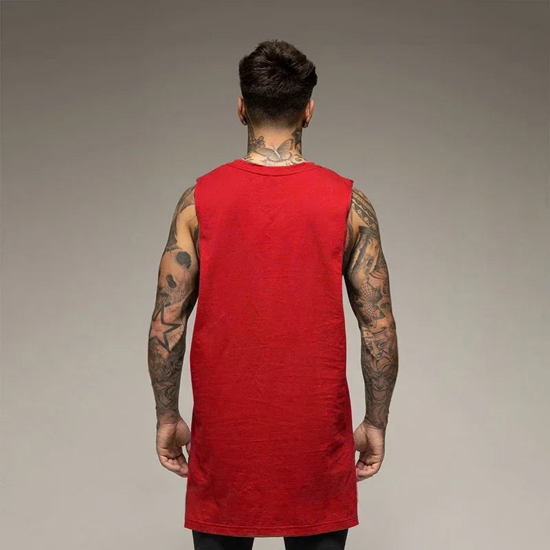 Back view of a man in a red sleeveless cotton tank top, showcasing his tattoos and sporty style.