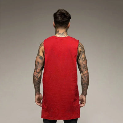 Back view of a man in a red sleeveless cotton tank top, showcasing his tattoos and sporty style.
