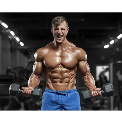 Muscular man lifting dumbbells in gym, emphasizing strength training and muscle gain.