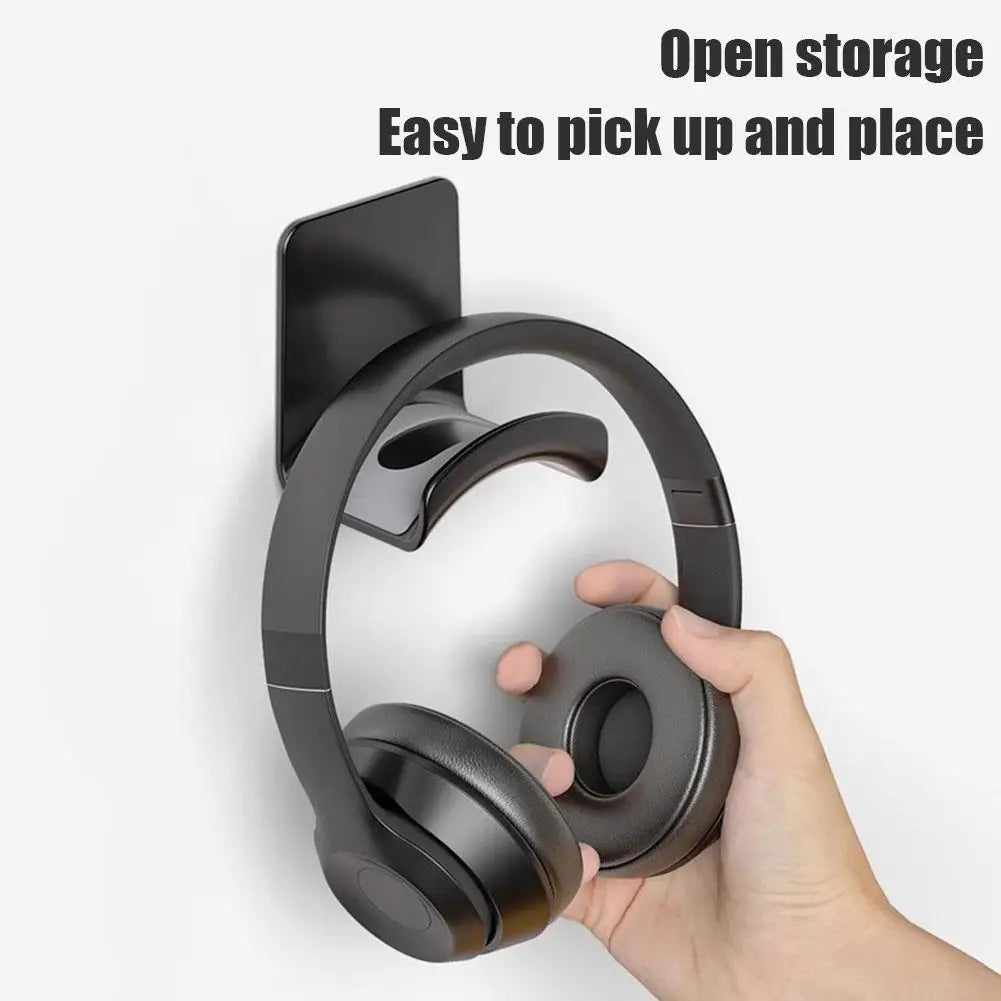 Universal headphone stand with open storage for easy access, featuring a sleek plastic wall mount design for under desk use.