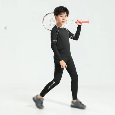 Boy wearing thermal compression sportswear for basketball and soccer, holding a tennis racket, in a stylish athletic pose.