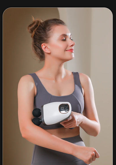 Woman using a double headed massage gun for deep tissue therapy and muscle relaxation.