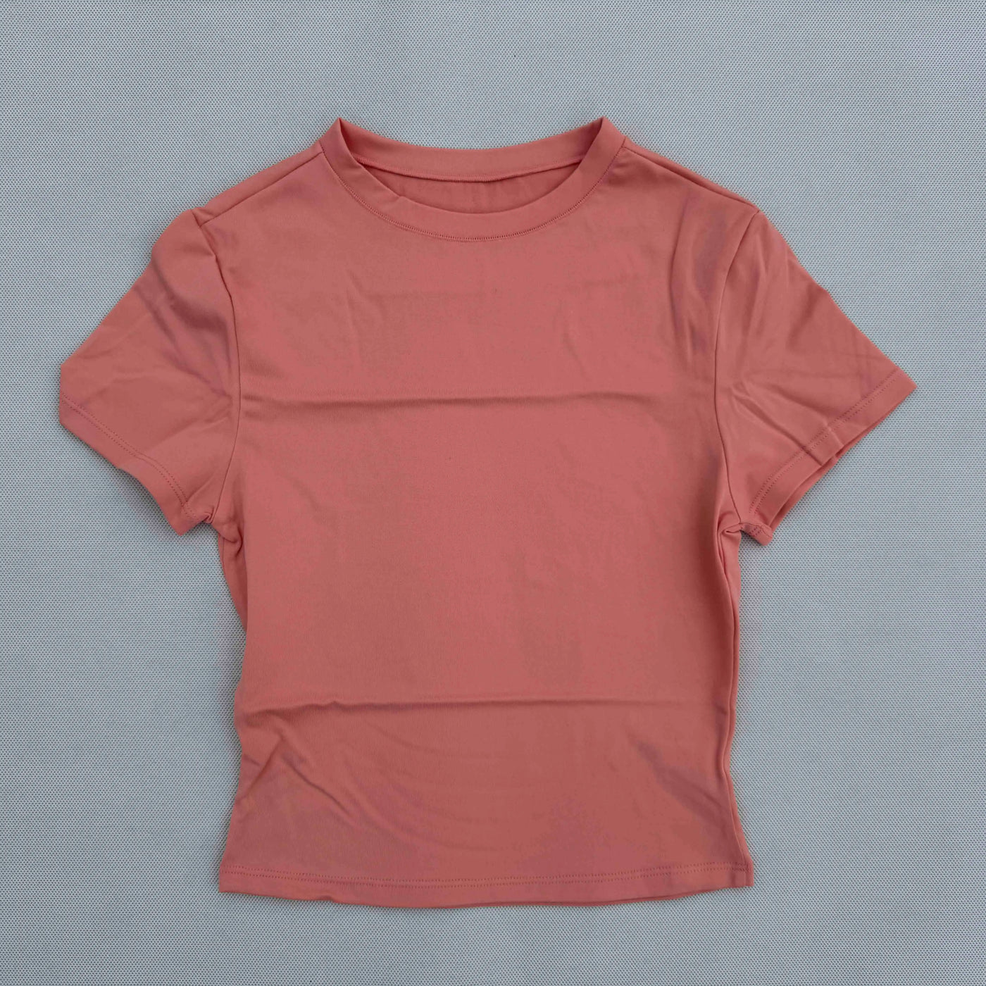 Women's short-sleeved quick-drying breathable sports T-shirt in coral color, perfect for yoga and fitness activities.