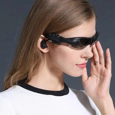 Woman wearing wireless sunglasses headset with Bluetooth earphones, ideal for driving and sports.