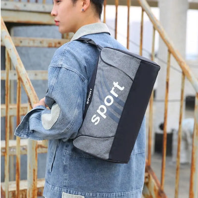 Grey gym bag with 'sport' text, worn on shoulder by a person in denim jacket, suitable for fitness and travel.