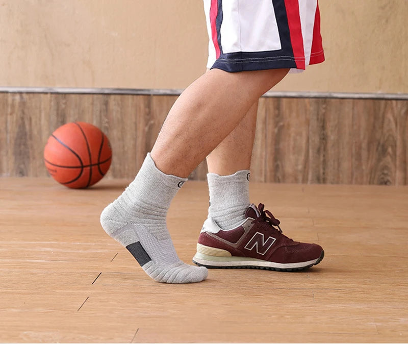 Man wearing breathable elastic compression sports socks while playing basketball on the court, showcasing comfort and performance.