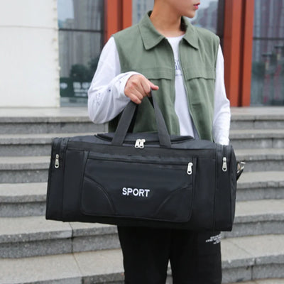 Man holding a large black sports duffel bag with 'SPORT' logo, ideal for gym and outdoor activities.