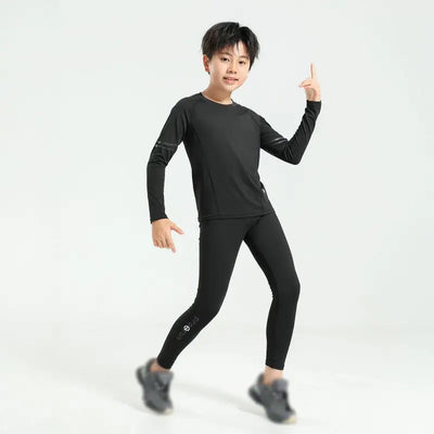 Young boy in black thermal compression sportswear set for basketball and soccer, showcasing flexibility and comfort.