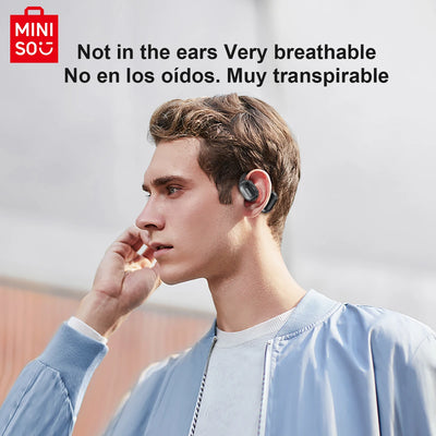Young man wearing MINISO MS162 Bluetooth translation earbuds, showcasing breathable design and wireless convenience.