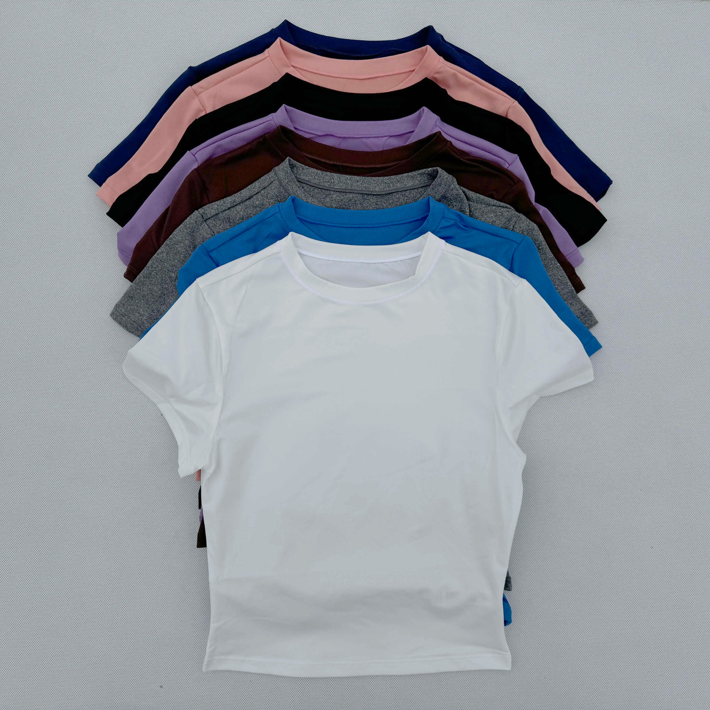 Collection of women's short-sleeved sports T-shirts in various colors, quick-drying and breathable fabric.
