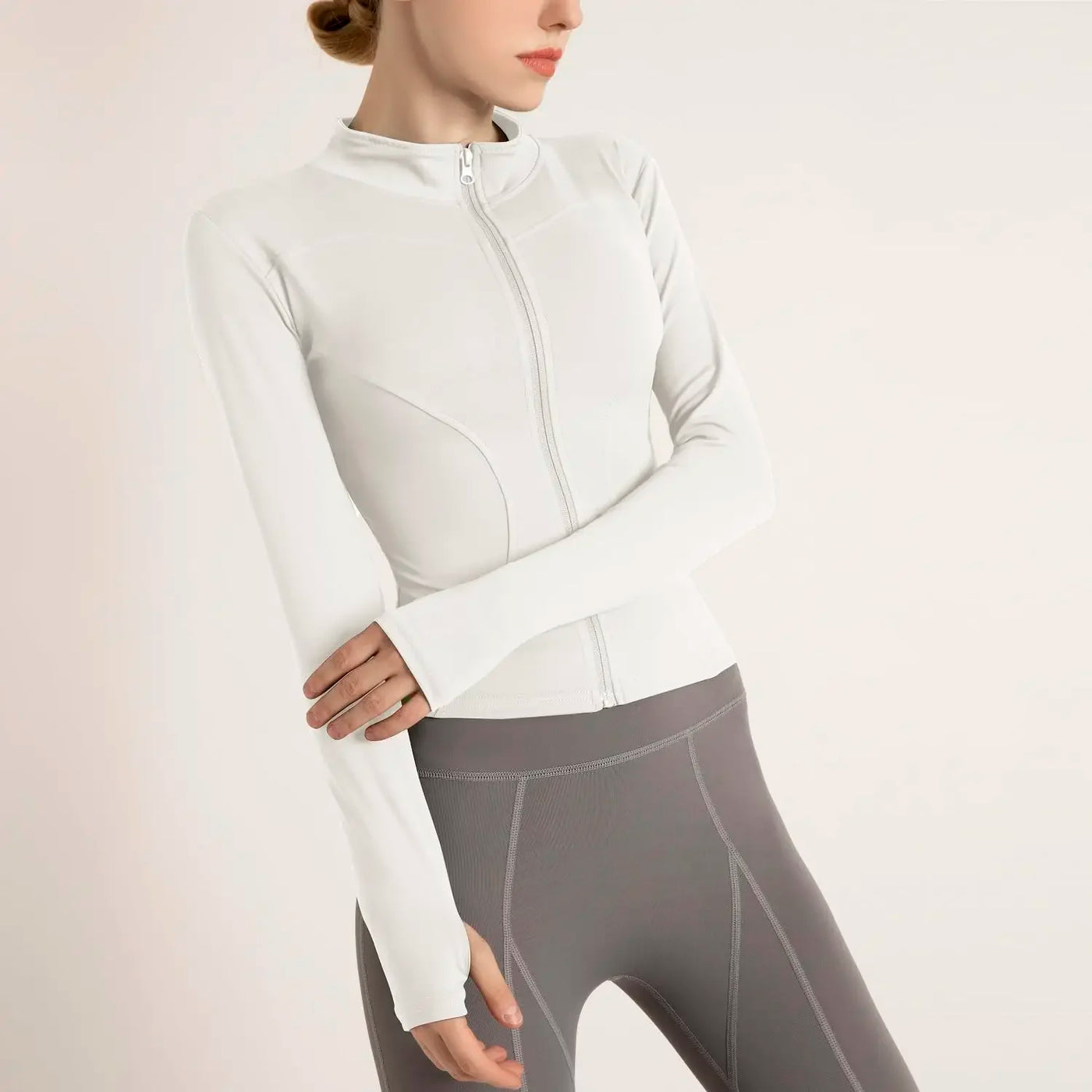 Women's lightweight sports jacket in white, featuring a zip closure and long sleeves, perfect for gym workouts and outdoor activities.