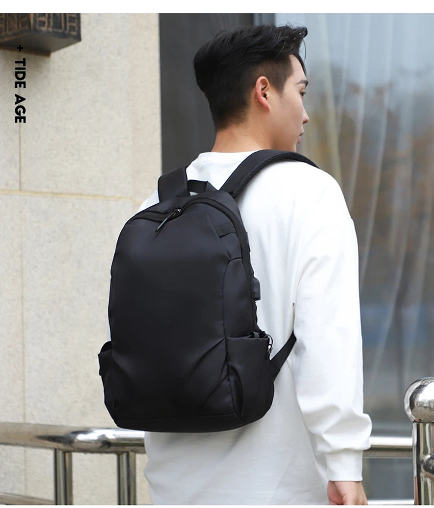 Black unisex backpack worn by a person, ideal for college students and daily use.