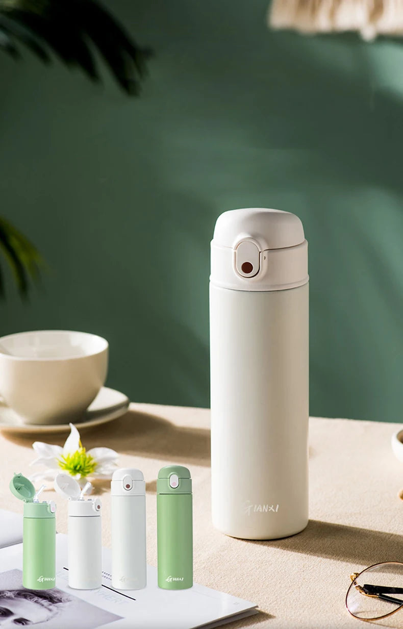 GIANXI stainless steel insulated water bottle in white, showcasing vacuum flask design with colorful options on a table.