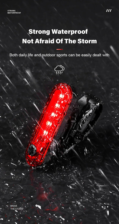 Waterproof USB rechargeable bike tail light illuminating in the rain, showcasing outdoor cycling safety.