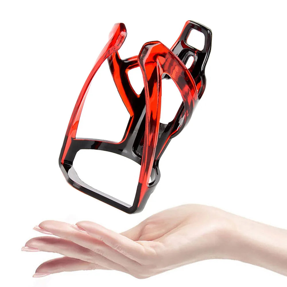 Lightweight red and black bicycle bottle cage held in hand, perfect water bottle holder for cycling enthusiasts.