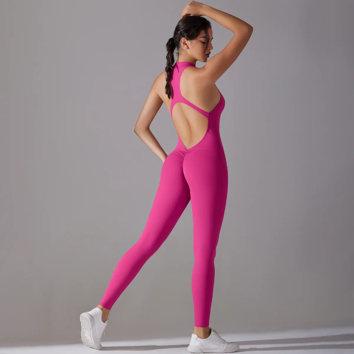 Women in a pink bodysuit showcasing back design, ideal for yoga and fitness activities.