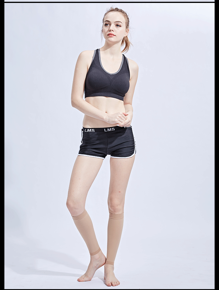 Model wearing a black sports bra and shorts, displaying compression calf socks for varicose veins and edema support.