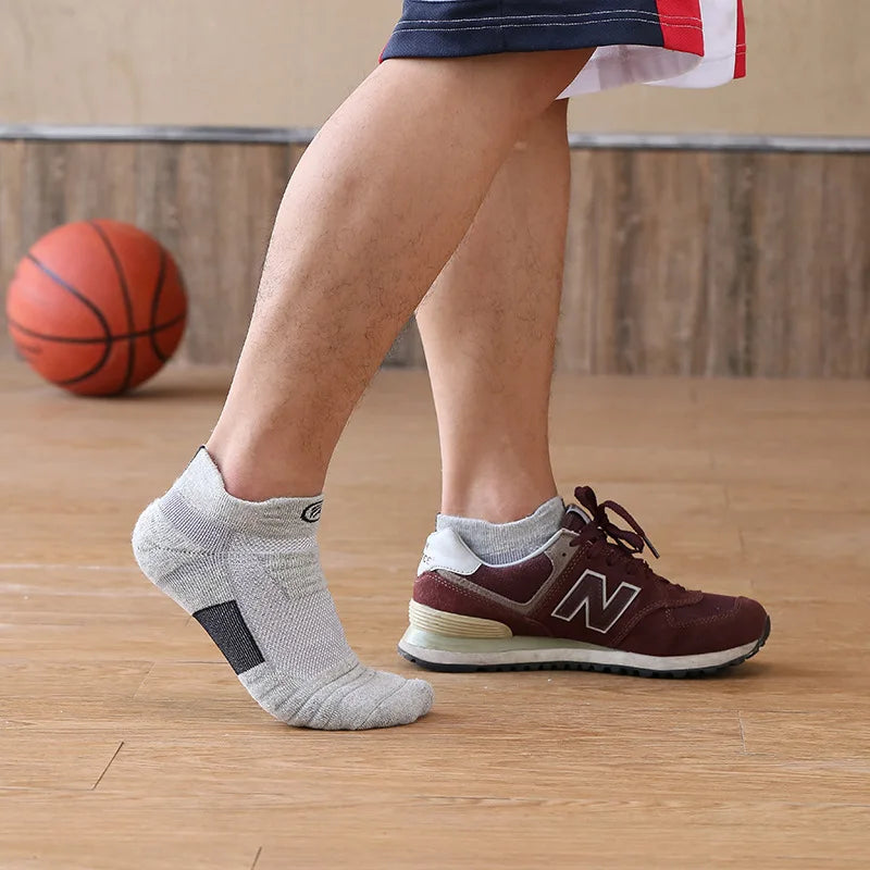 Man wearing elastic compression sports socks with basketball and sneakers for optimal performance.