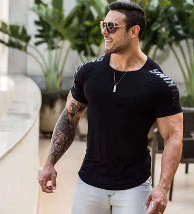 Stylish man in a black short-sleeve fitness tee, showcasing comfort and athletic style in a summer setting.