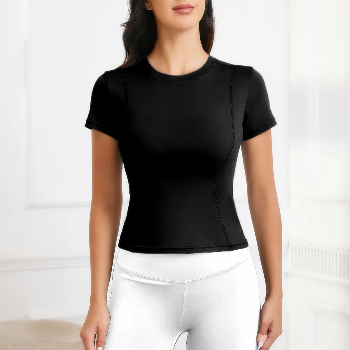 Women's short sleeve black workout top for yoga and athletic activities, breathable nylon material.