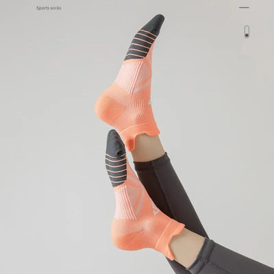 Breathable sports socks in orange and black for men and women, ideal for running and fitness activities.