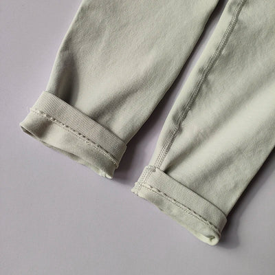 Close-up of the cuffs on seamless women's yoga leggings in light grey fabric, highlighting knit texture and design.