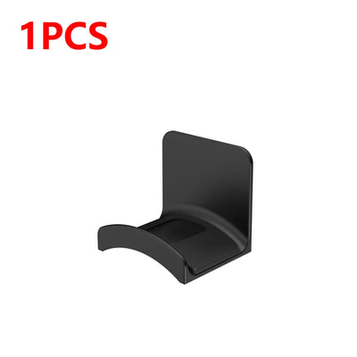 Universal adhesive headphone hanger, wall mount headphone holder, sleek black design for easy organization.