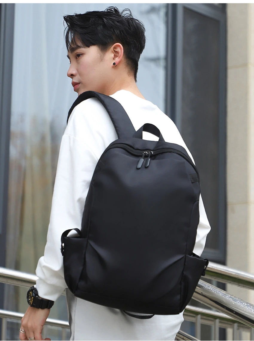 Stylish unisex softback backpack in black worn by a young male, perfect for college and everyday use.