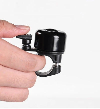 Loud aluminum alloy MTB bicycle bell being held in hand, designed for safety and easy installation on handlebars.