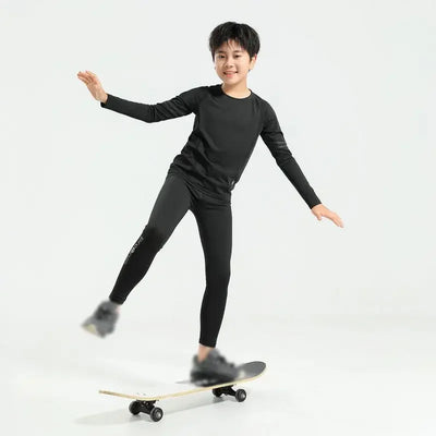 Young boy in black thermal compression sportswear skating on a skateboard, demonstrating quick-dry flexibility and style.
