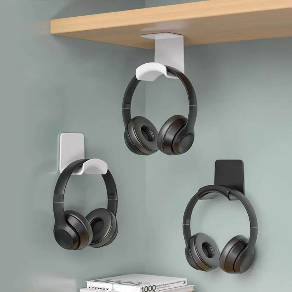 Universal headphone stand adhesive plastic wall mount holder for gaming earphones, neatly organized under desk.