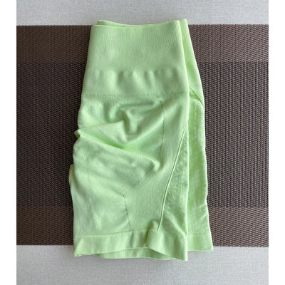 Bright green seamless women's workout shorts, perfect for yoga and gym activities, made from nylon and spandex.
