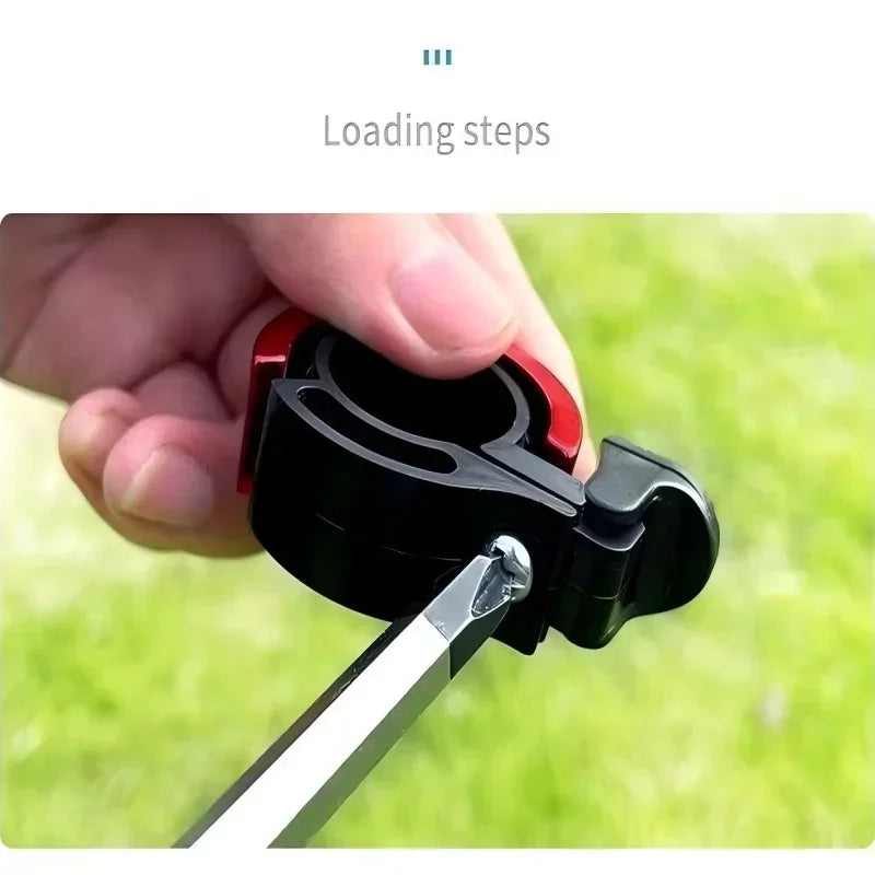 A close-up of a hand loading a bike bell mechanism, showcasing the assembly process in the outdoors.