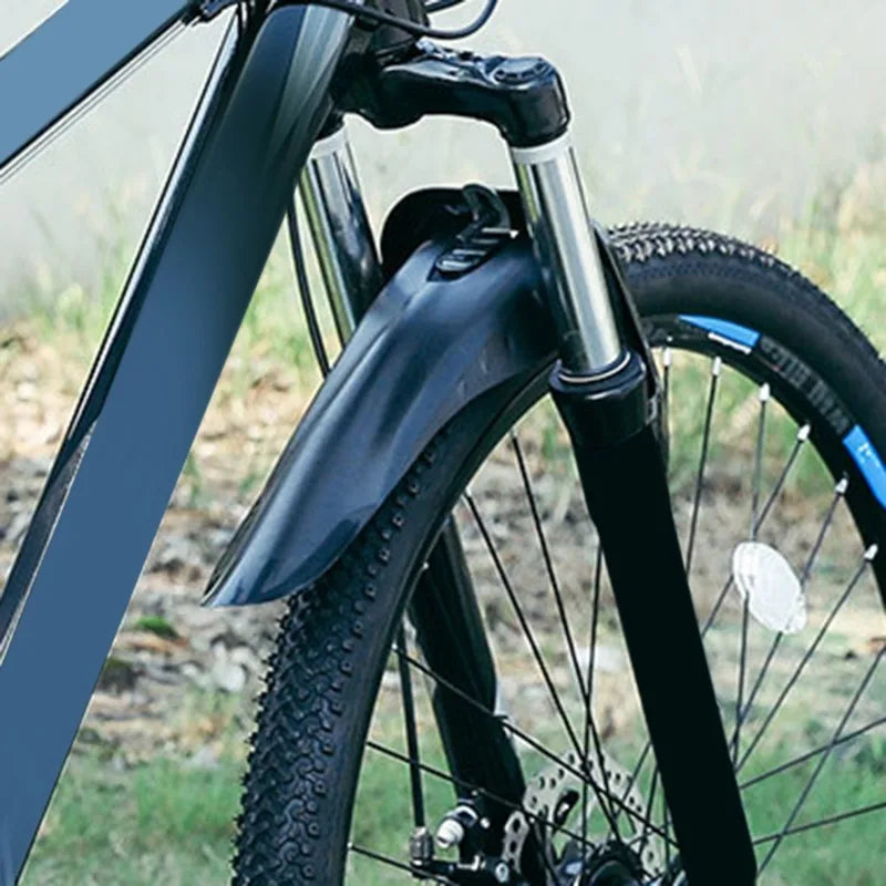Bicycle fender made of soft plastic, providing splash protection for mountain bikes in outdoor settings.