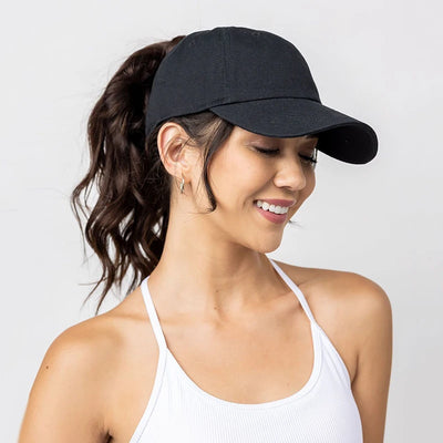 Woman wearing a high ponytail baseball cap, perfect for sports like running and golf, in a casual outdoor setting.