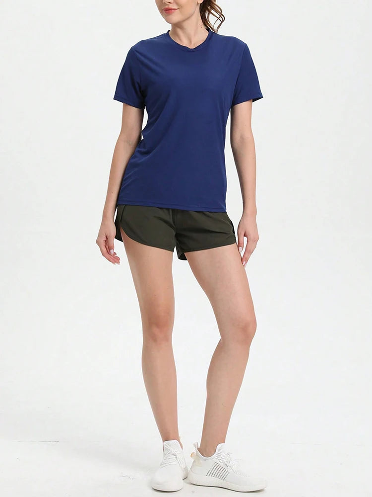 Model wearing women's solid color ultralight quick dry sport t-shirt with shorts, ideal for running and gym activities.